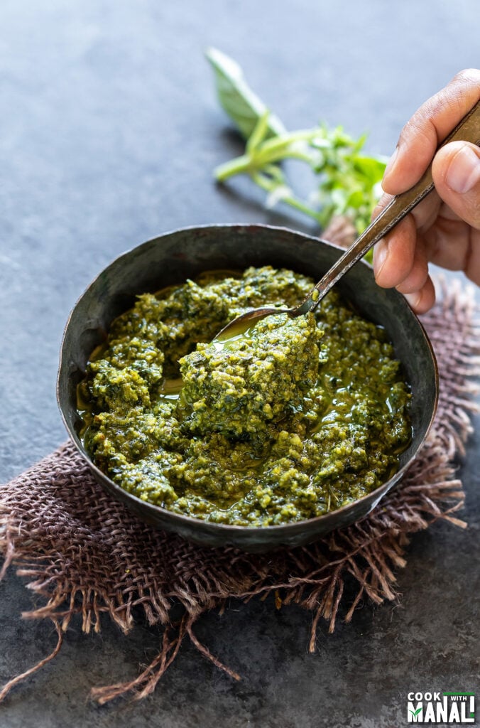 spoon digging into a bowl of vegan pesto
