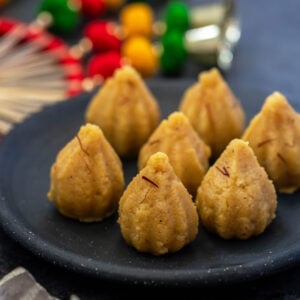 7 mawa modak arranged in a black round plate