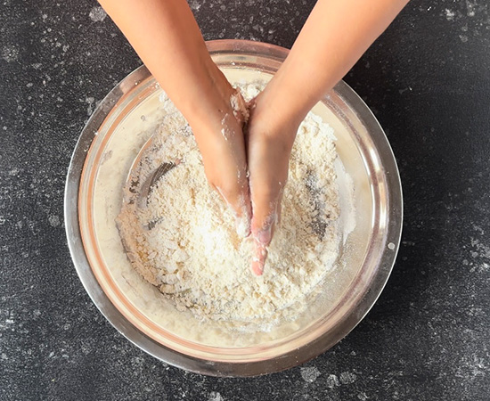 mixing the ghee with flour by rubbing it between your hands